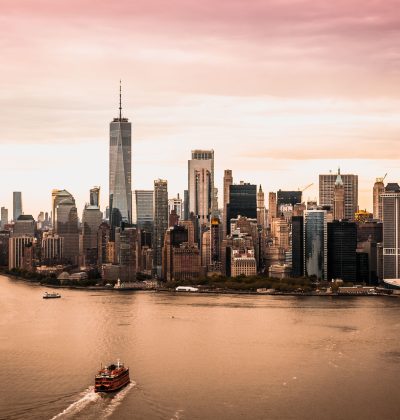 Aerial view of the Manhattan skyline and Hudson River under a sunset sky