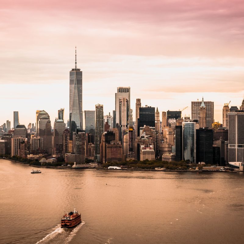 Aerial view of the Manhattan skyline and Hudson River under a sunset sky
