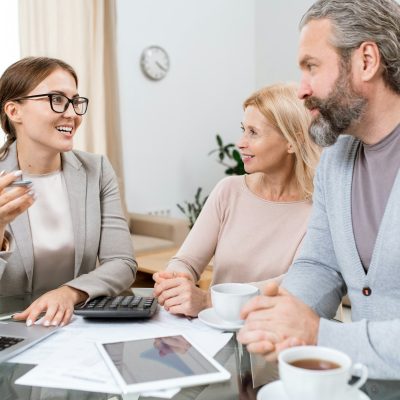 Young cheerful financial advisor or agent consulting mature husband and wife